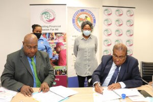 CIC Acting Chief Executive Officer Charles Dambui (seated left) and CEFI Executive Director Saliya Ranasinghe sign the MoU Documents. Witnessing the signing are CIC Company Secretary Wilma Banake (left standing) and CEFI Head Trainer Jill Pijui.
